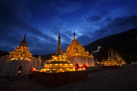 Monks celebrating Full Moon Day light thousands of small oil lamps around a pagoda in Pindaya, a small town near Inle Lake.