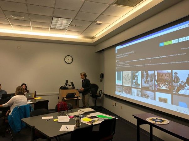 A workshop presenter is discussing a Learning Lab collection projected onto a large screen in front of a classroom.