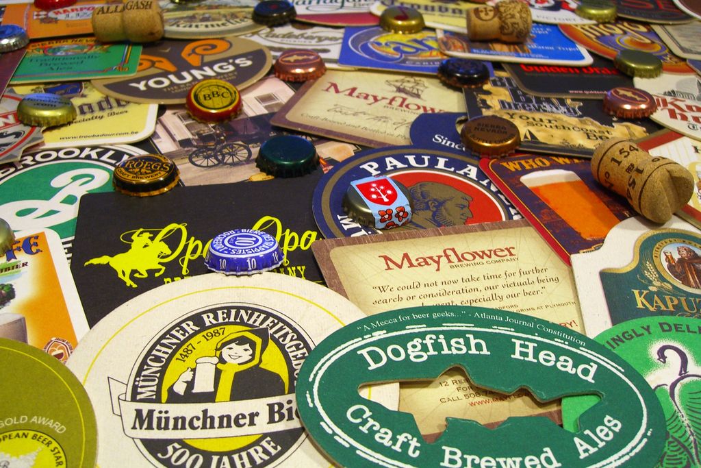A pile of various beer coasters, wine bottle borks and metal beer bottle caps