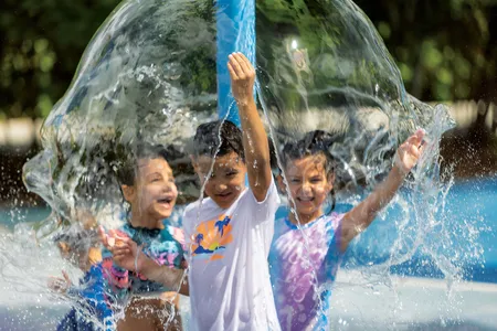 Kids cool down at an animal-themed splash pad at Zoo Miami. Mist stations also help visitors avoid overheating on sweltering days.