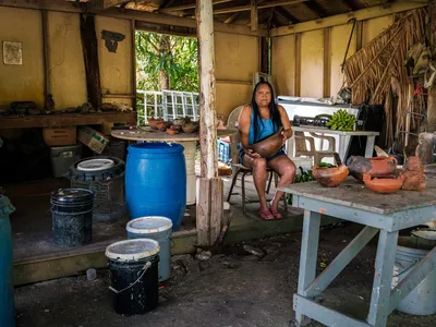 a women sits for a portrait in her pottery workshop