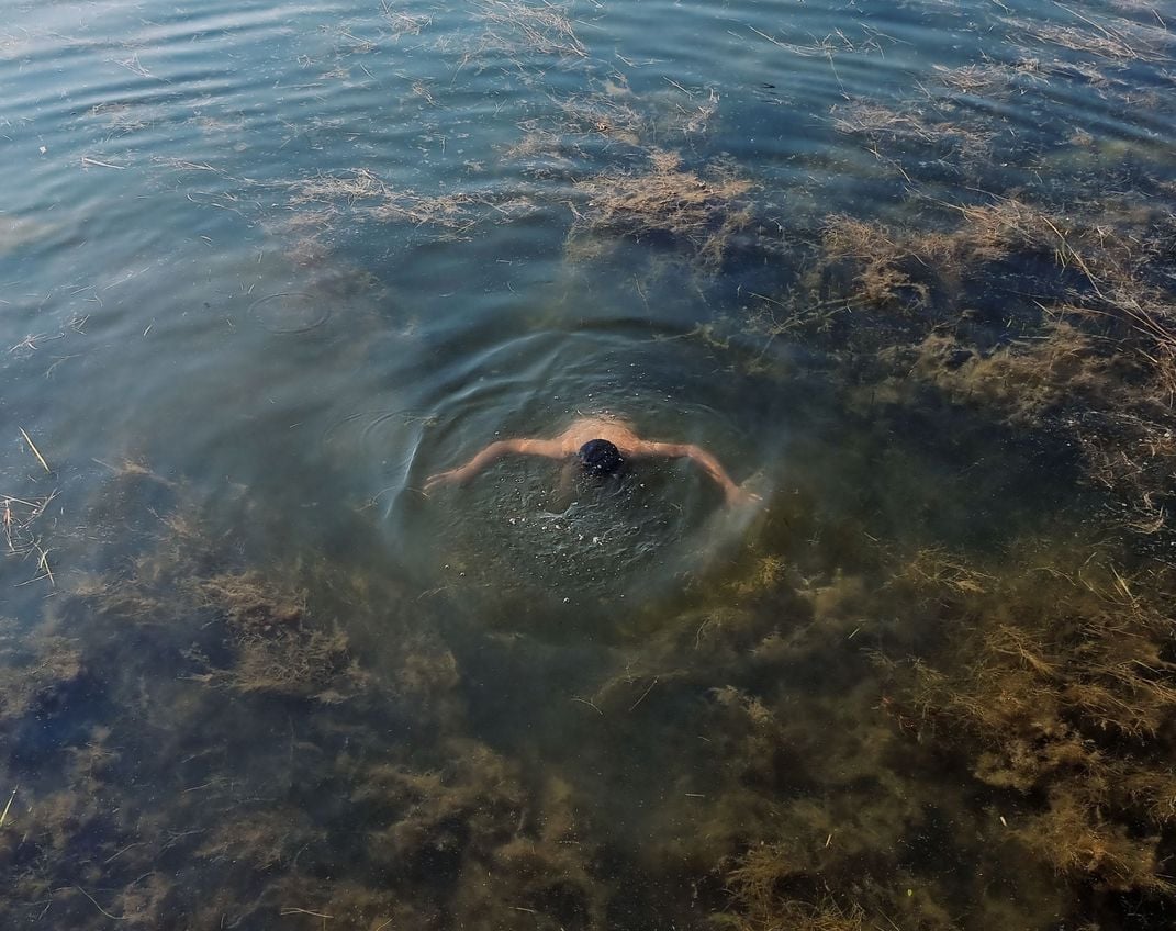 一个人脸朝下躺在浑浊的水中