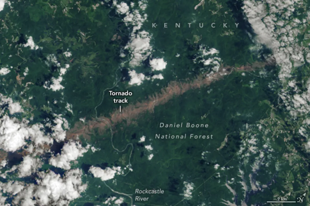 A close-up and labeled version of NASA's satellite image featuring the tornado's trail of destruction visible through clouds.
