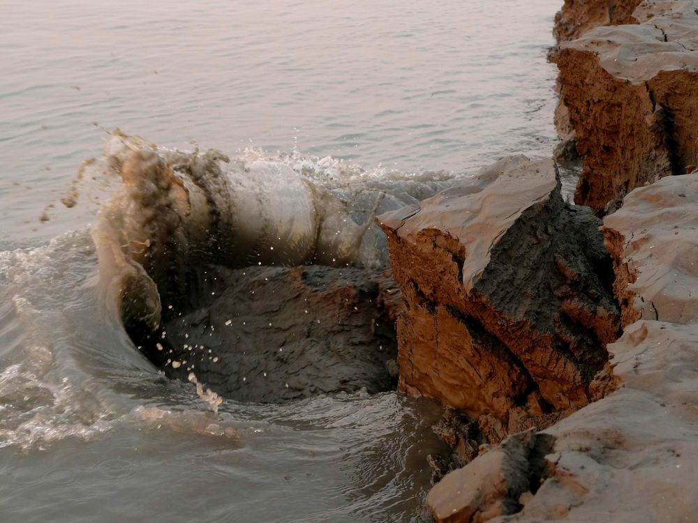 Large chunks of mud breaking off as the tide rolls out of Knik Arm