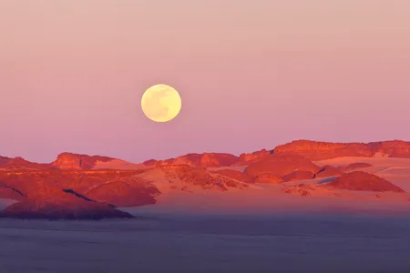 The moon rises over the Sahara Desert. New research links a rising moon to lower humidity and a decreased chance of rain. 