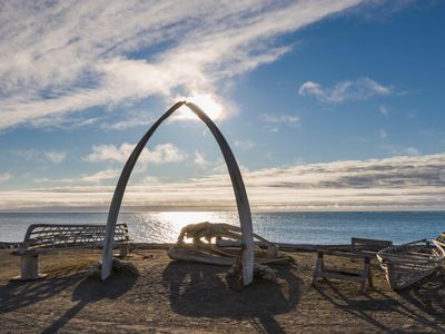 An arch made from a bowhead whale jaw stands over traditional whaling boats in Barrow, Alaska.