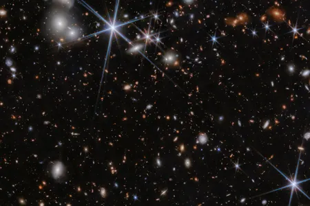 The environment surrounding the galaxy system where the two black holes are merging. The event is occurring in the distant universe, around 13 billion years ago.