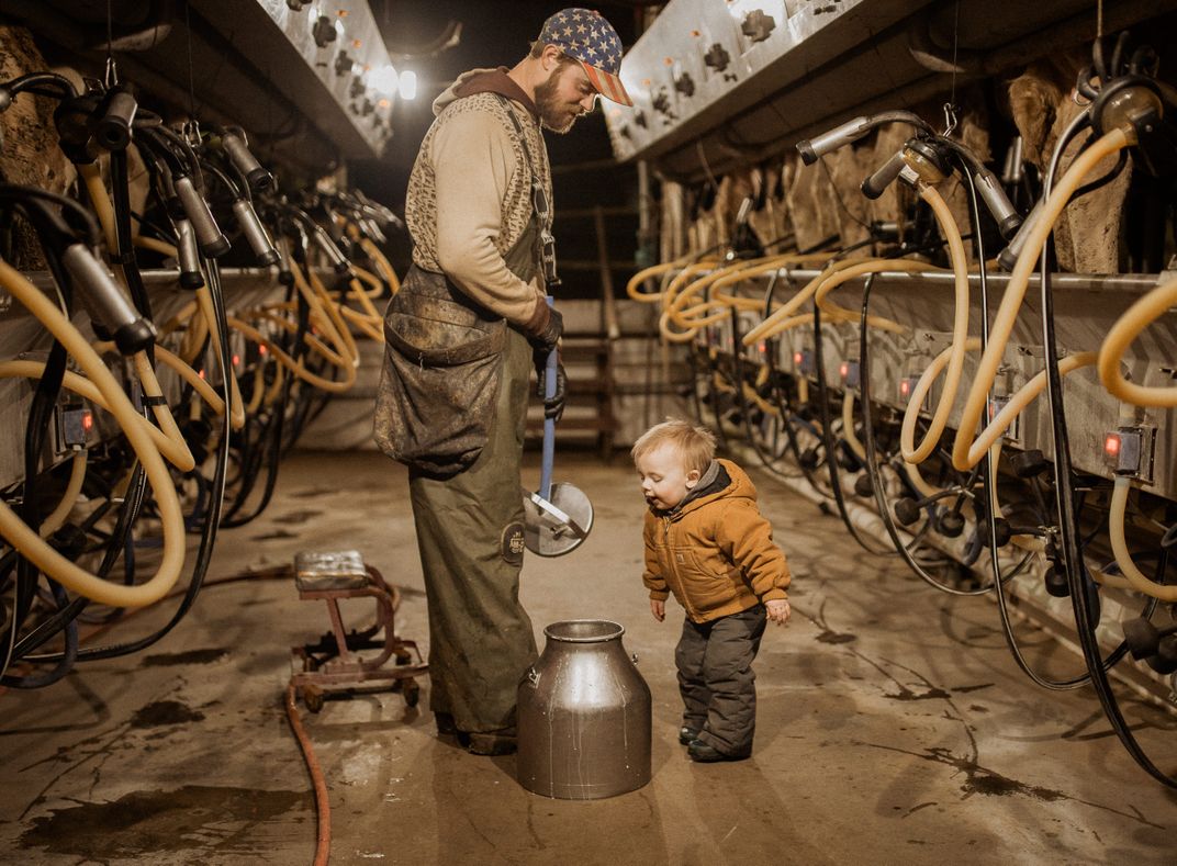 Father and son in a dairy barn