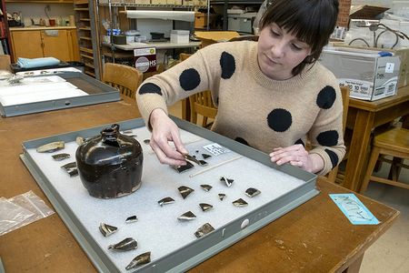 Archaeologist Kate Kolwicz examines fragments of late 19th-century Chinese pottery unearthed in downtown Missoula.