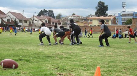 Footballer in the making? This young Ecuadorian seems drawn to the oblong shape and peculiar design of a football on a soccer field in the city of  Cuenca.