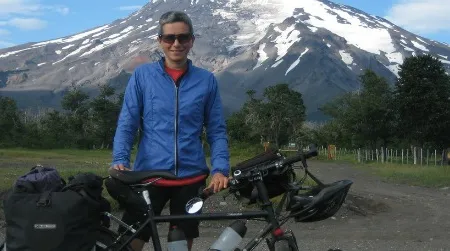 Pauline Symaniak, shown here before Volcan Lanin in Argentina, has been pedaling around the earth for 18 months. Much of New Zealand has failed to amaze her.