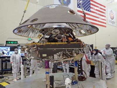 The back shell of NASA’s InSight spacecraft being lowered onto the lander, last July, in preparation for the mission. 