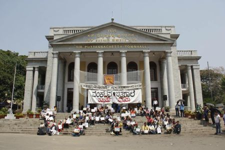 Protestors sit outside a local town hall.