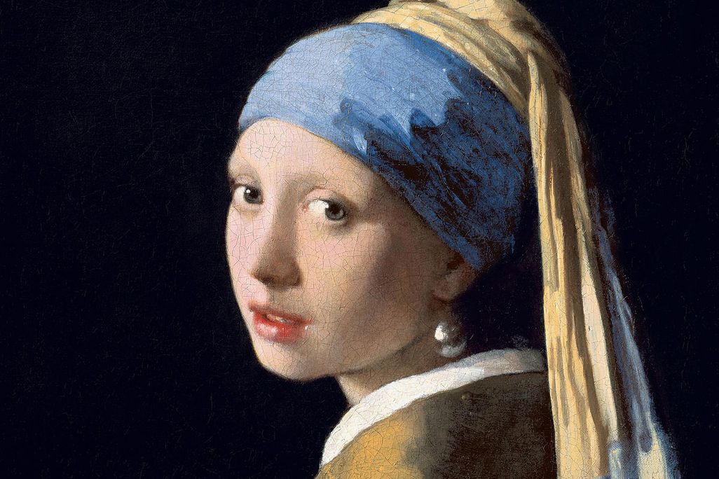 A portrait of a young white woman framed by an all-black background; she turns toward the viewer and wears a blue headscarf and one large, illuminated earring dangling from her left ear; her lips are slightly parted