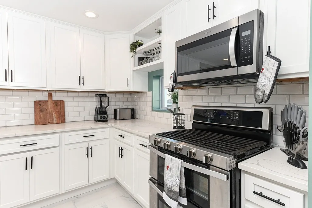 A microwave in a kitchen with white cabinets