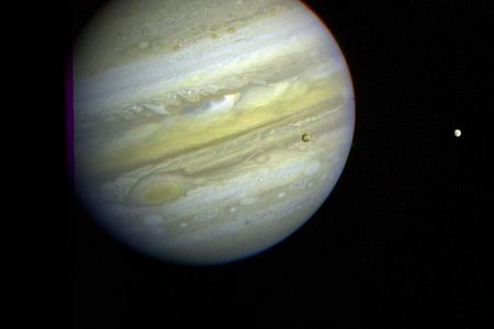 Three of Jupiter’s moons, Callisto, Io, and Europa can be seen orbiting the gas giant.