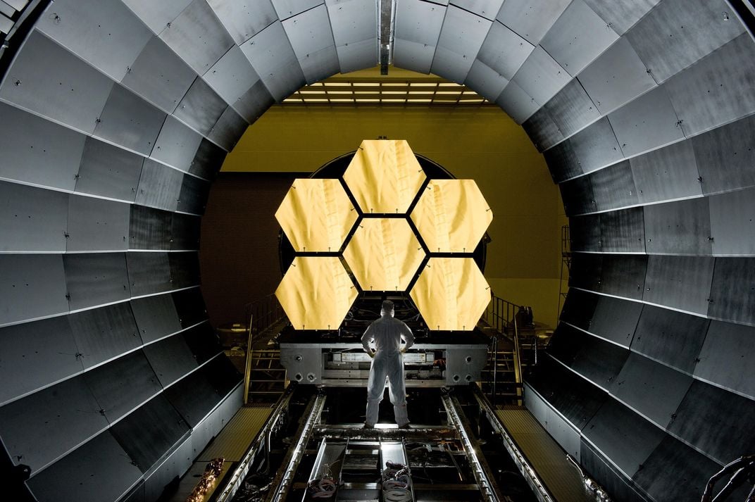 person looking at giant segmented mirror