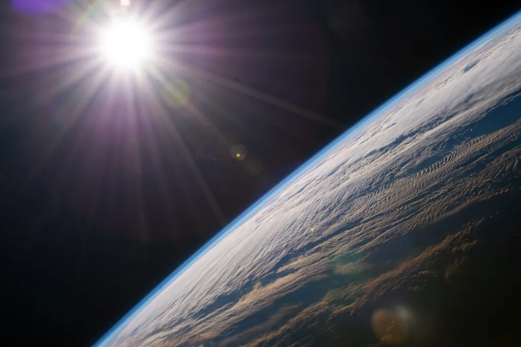 Sun shining light onto Earth as seen from space