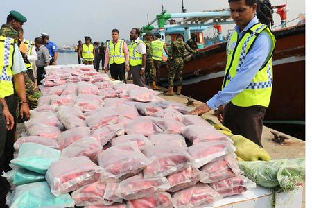 Sri Lankan police stand next to over $33 million worth of heroin and crystal methamphetamine seized from two foreign trawlers.