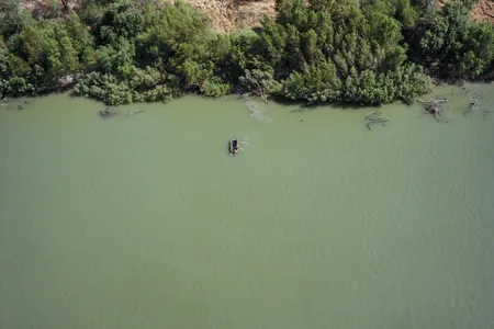 After U.S. Border Patrol spots their raft, migrants speed back toward the Mexico side of the Rio Grande.