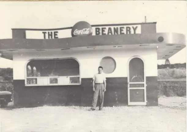 Garneau standing in front of his first curb-service restaurant, The Beanery, in 1949.