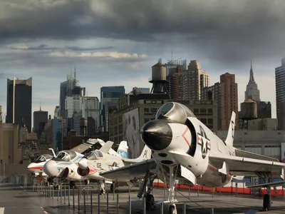 Complementing the New York City skyline, from right: a McDonnell F3H Demon, Vought F-8 Crusader, Grumman A-6 Intruder, and Grumman F-14D Super Tomcat.

