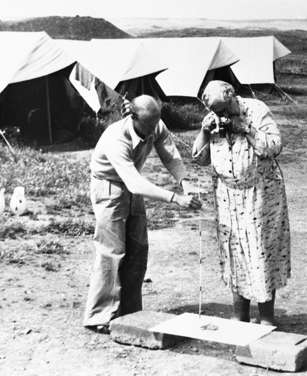 Agatha Christie photographs an Assyrian ivory figure at          Nimrud in Iraq