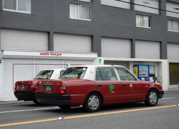 red taxis sitting side by side on a street in Kyoto thumbnail
