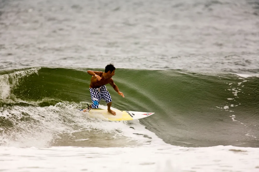 a surfer goes sideways across a breaking wave