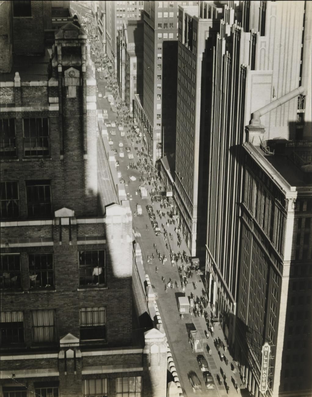 A black and white photograph looking down on a street in Manhattan