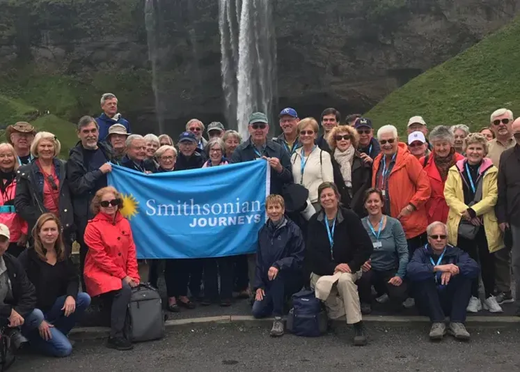Smithsonian Journeys travelers in front of the Seljalandsfoss waterfall