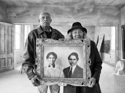 Elroy and Sophia Williams stand inside the Hopewell School, a site on the National Register of Historic Places. Once freed from slavery, Sophia&rsquo;s grandparents, depicted in the artwork she holds, acquired and then donated land for the school, one of nearly 5,000 built for African American children across from 1912 to 1937.