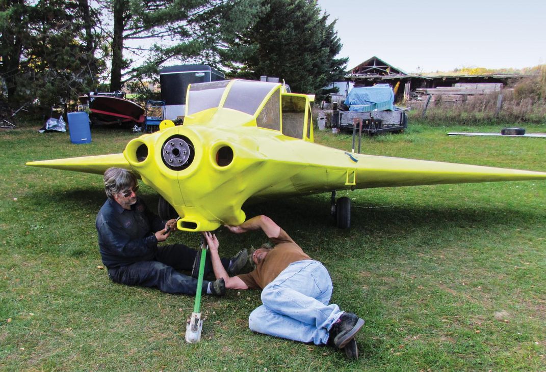 two men working on a chartreuse Delta