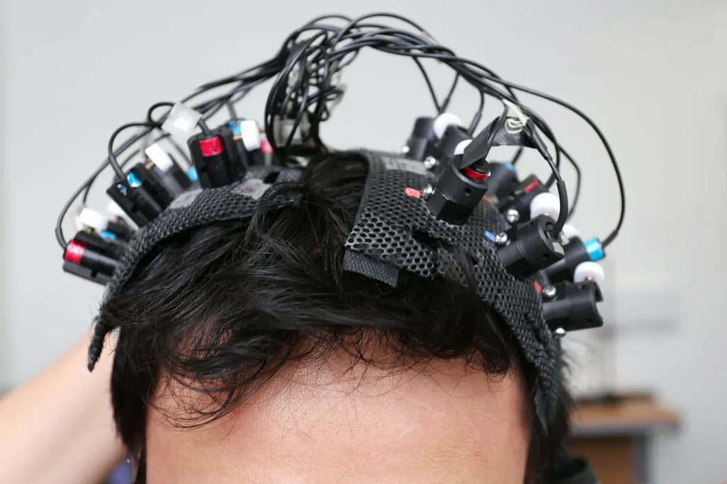 A man's head with many wires and electrodes attached to his scalp