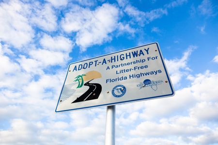 This Adopt-A-Highway sign is located on the Florida Keys Scenic Highway. The program, which began in Texas, is now used by states across the country.