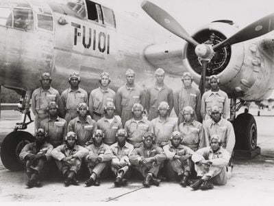 Men of the all-African American 477th Bombardment Group pose in front of a North American B-25 Mitchell.