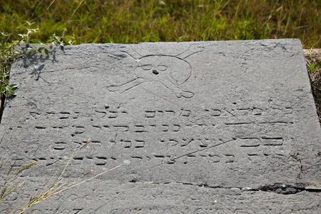 A grave marker in Kingston's Hunt's Bay Cemetery carved with a skull and crossbones and Hebrew lettering