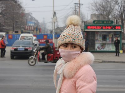 A woman wears a mask to protect against air pollution in Anyang. New research shows that Northeastern China could get more polluted when there is lest dust in the air. 