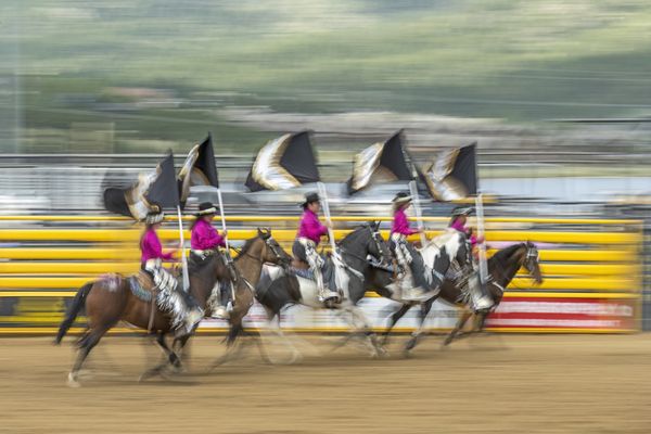 Color guard members gallop through the arena during the Rooftop Rodeo thumbnail