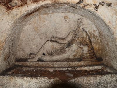 The tomb&rsquo;s centerpiece carving depicts a reclining man.