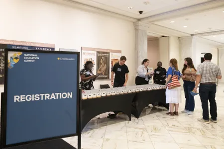 A sign says Registration and a group of people approach a table