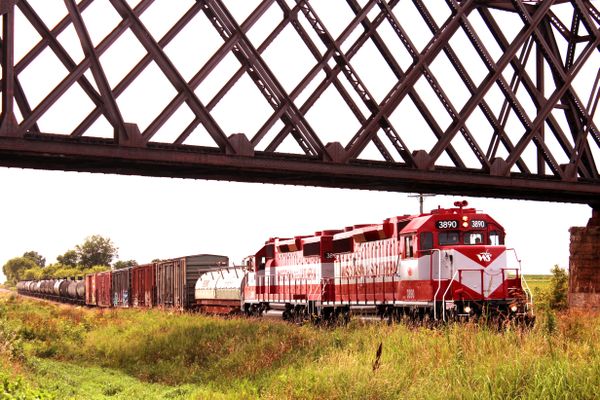 Wisconsin Southern train under an iron rail trestle in Friesland, WI thumbnail