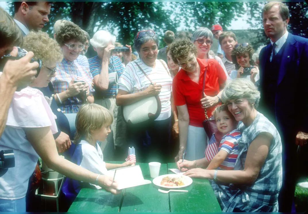 Ferraro holding a child at a picnic table in Minnesota