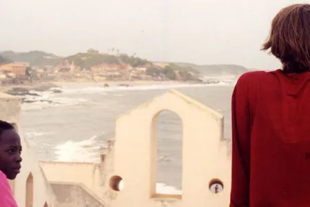 Katrina Browne and a Ghanaian child on the ramparts of Cape Coast Castle slave fort.