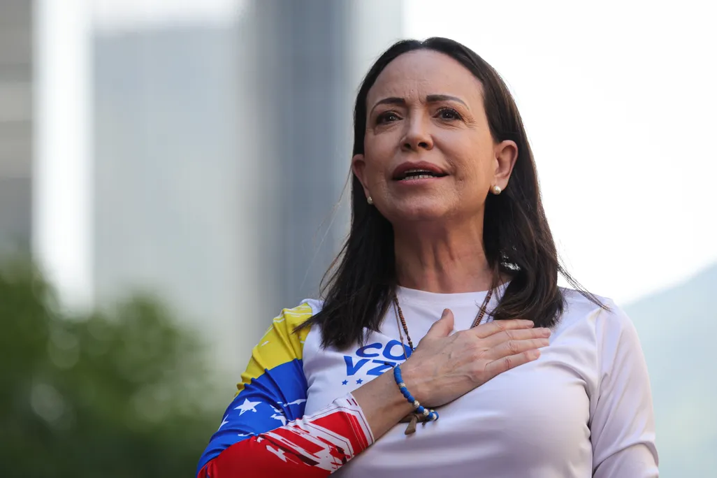 Woman with dark hair with her hand across her heart
