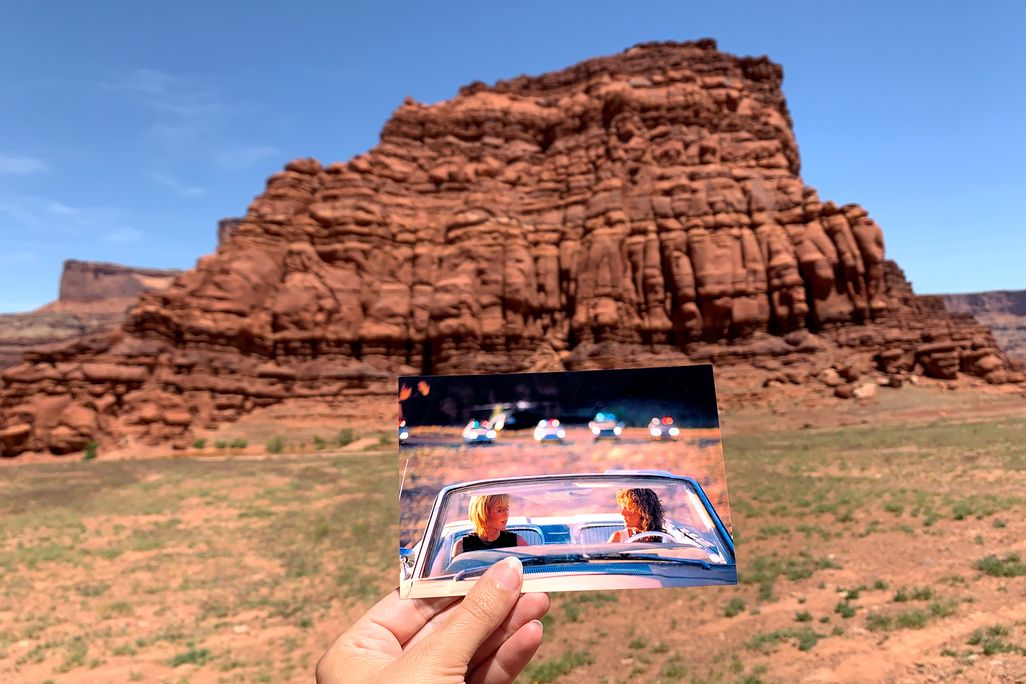 Person holding up a snapshot from the movie "Thelma & Louise" in front of rock formation