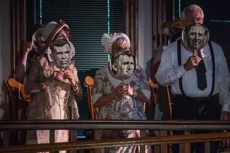 Local actors Judy Barth, Ruth Ochsenrider and Jim Barth peer over photos of original Scopes Trial jurors during the annual Scopes Trial Festival in Dayton, Tennessee.