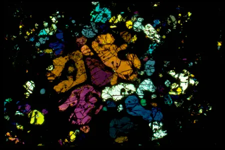 A polarized-light microscopy image (in background) of a section from the Allende meteorite is one-thousandth of a millimeter thin.
