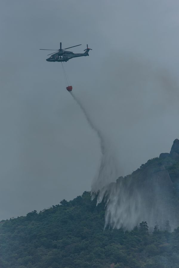 A Government Flying Services helicopter puts out a hill fire thumbnail