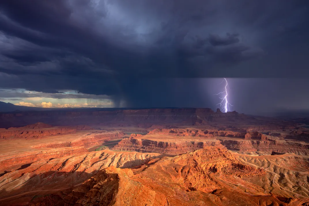 8 - Like a scene from a sci-fi movie, lightning pierces the darkness in the distance, seemingly foreshadowing something ominous on a planet with reddish terrain.